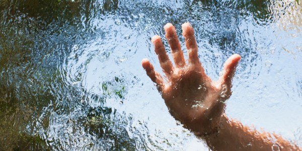 Hand reaching out behind glass